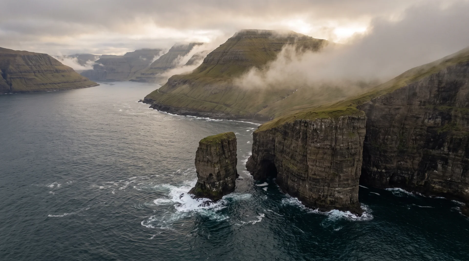 Cinematic aerial view of fog over Faroe Islands sea cliffs